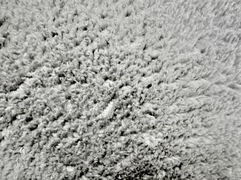 Plush gray wool rug texture reveals soft organic pile details in minimalist o 库存照片