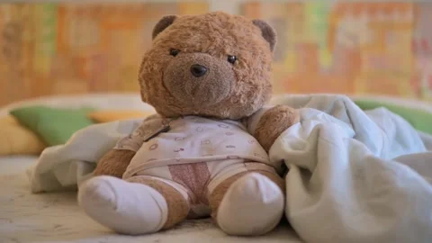 Plush Teddy Bear Sitting on Bed With Blanket in Cozy Nursery, Soft Toy Comfort Stock Footage 331901784