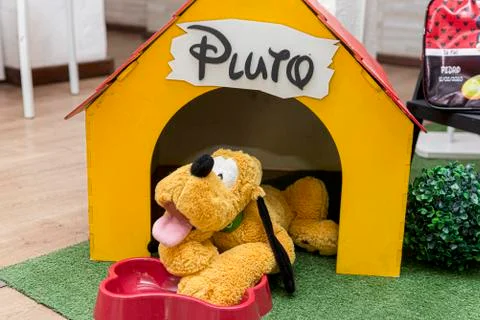 Pluto teddy bear in his yellow wooden house. Stock Photos