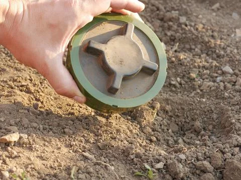PMN-2 soviet anti-personnel mine buried in a man's hand Stock Photos
