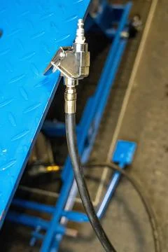 Pneumatic hose coupling connecting to a blue metal structure Stock Photos