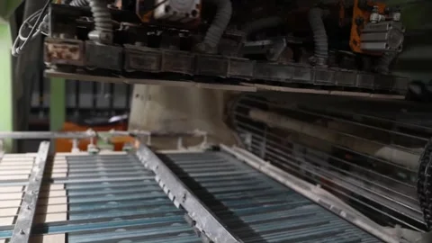 Pneumatic pick and place unit hovers above rows of raw tiles on a factory Vídeo Stock 346737641