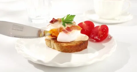 Poached egg cuts with knife. poached egg toast. sunny day. angle view. Stock Footage 243228815