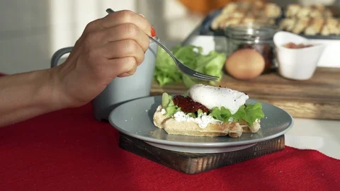 Poached egg on a piece of bread with green lettuce leaves on a plate rotates Video stock 97212997