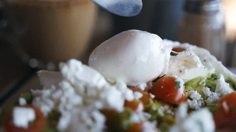 Poached egg on a piece of bread with green lettuce leaves on a plate with tomato Stock Footage 127037136