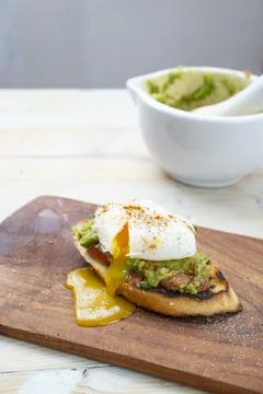 Poached egg on a slice of toast bread, with guacamole Stock Photos