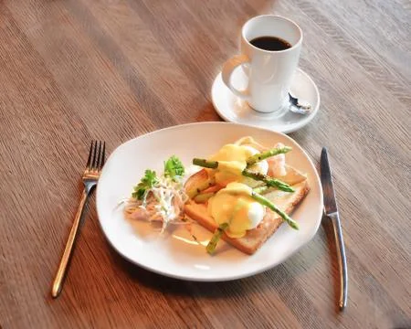 Poached egg on toasted white bread with bacon, young asparagus and cole slow Stock Photos
