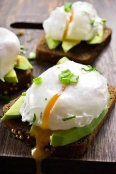 Poached eggs and avocado on bread Stock Photos