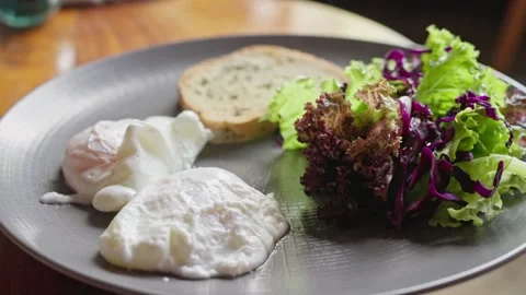 Poached eggs breakfast dish with bread and salad Healthy breakfast or lunch food Stock Footage 251719963