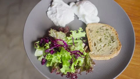 Poached eggs breakfast dish with crispy bread, vegetables salad. top view 库存影片 252037521