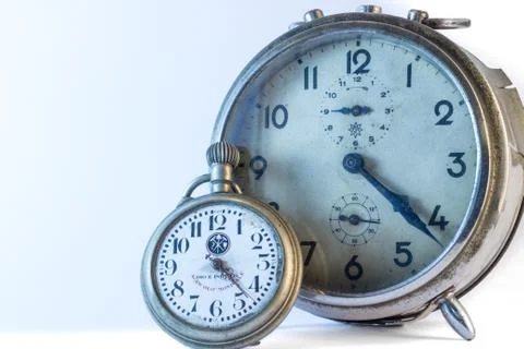 Pocket and old alarm clock. Stock Photos