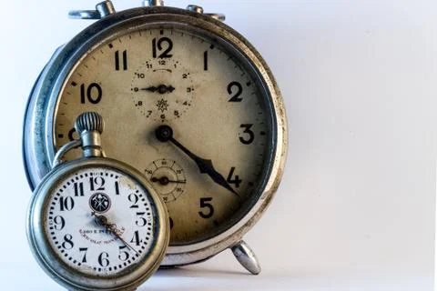 Pocket and old alarm clock. Stock Photos