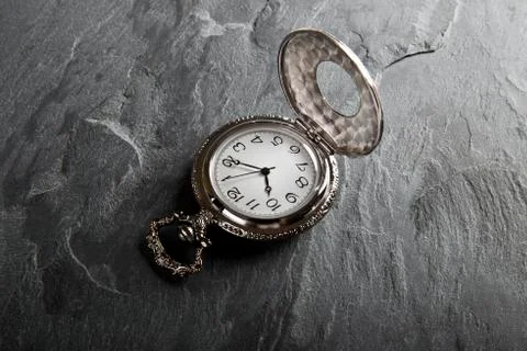 Pocket gray clock on dark gray Stock Photos