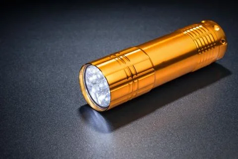 Pocket LED light on a dark surface. Stock Photos