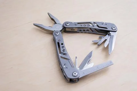 Pocket multitool with various blades and components partially opened, highlig Stock Photos