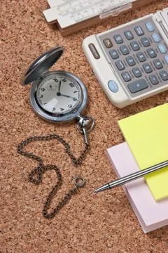 Pocket watch and scratch paper on a cork board Stock Photos