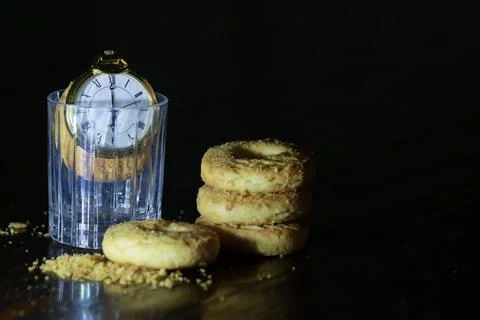 Pocket watch on biscuits in dark Stock Photos