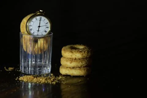Pocket watch on biscuits in dark Stock Photos