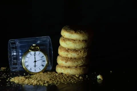Pocket watch on biscuits in dark Stock Photos