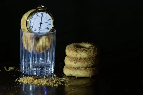 Pocket watch on biscuits in dark Stock Photos