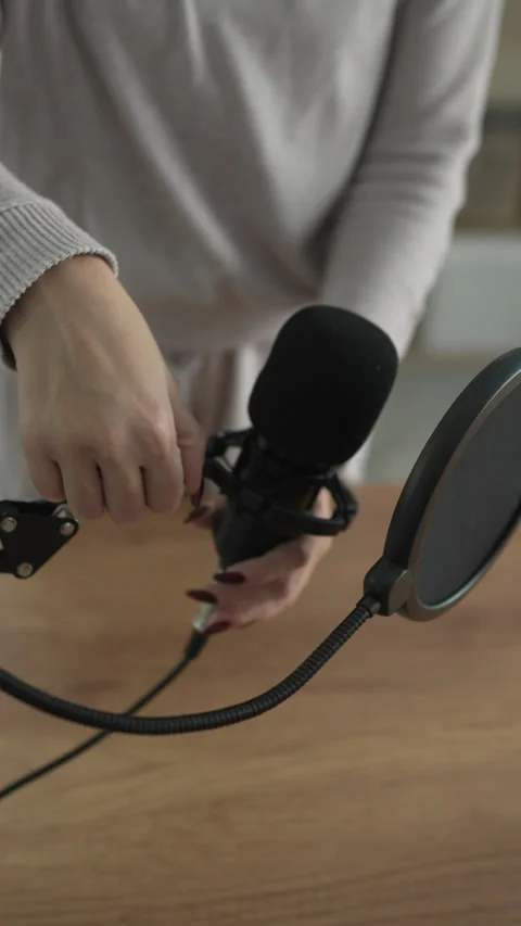 Podcast microphone set up with pop filter on wooden desk at home studio Stock Footage 293809564