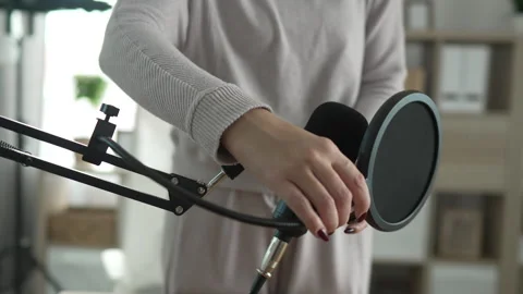Podcast microphone set up with pop filter on wooden desk at home studio Stock Footage 293809565