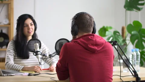 Podcast programme recording lady talks into mic with man Spbd Video stock 156876202