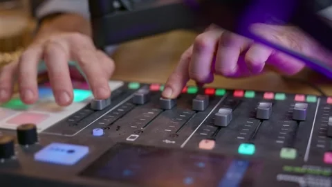 Podcaster's hands adjusting knobs, sliders, and buttons on professional audio 스톡 동영상 299874039