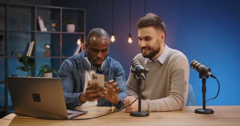 Podcasters recording live broadcast, men using smartphone, creating content Stock Footage 328973328