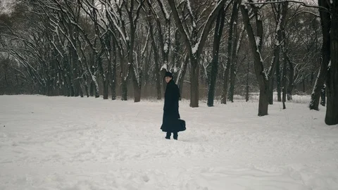 Point of interest shot: A man character in black cloak and hat stands and looks Stock Footage 102184048
