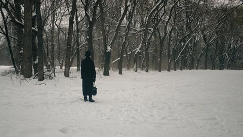 Point of interest shot: A man character in black cloak and hat stands and looks Vídeos de archivo 102184622