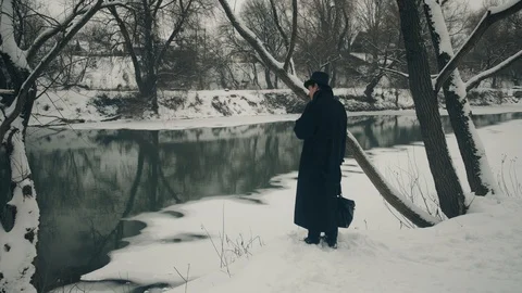 Point of interest shot: A man stands on the banks of the river and looks around 스톡 동영상 102176641