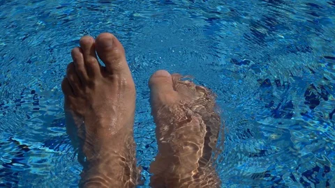 The point of looking at a man who sits on the edge of the pool and dances wit Stock Footage 108735701