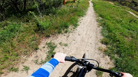 Point of View as 5 year old boy rides bike down mountain biking path 스톡 동영상 191235439