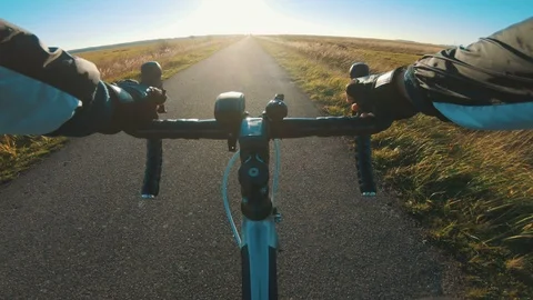 Point of view of athlete riding his racing bicycle on small and sunny road Stock Footage 98761379