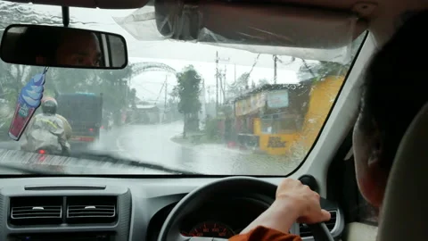 Point of view from the back seat on Balinese car driver in the heavy rain in Stock Footage 185586534