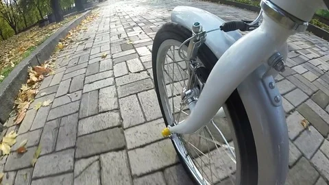 Point of view camera filming. Wheel of bicycle rides on  autumn  sunny city par Stock Footage 83672318
