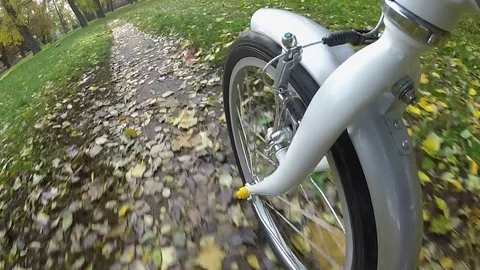  Point of view camera filming. Wheel of bicycle rides on  autumn  city park with Video stock 83672339