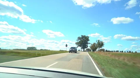 Point of view of car driving down country road during daytime Stock Footage 122174093