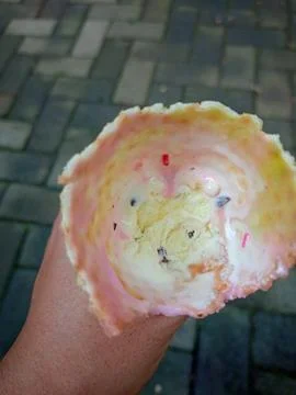 Point of view close-up of a hand holding a partially eaten ice cream cone. Stock Photos