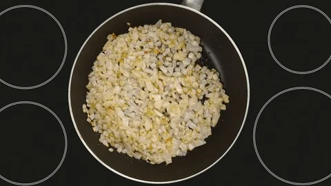 The point of view of the cook, which fry the onions in a frying pan. Ceramic  Stock Footage 95118119