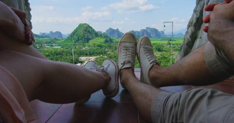 Point Of View: Couple's feet overlooking the mountain coastline of Thailand Asia Stock Footage 201096833