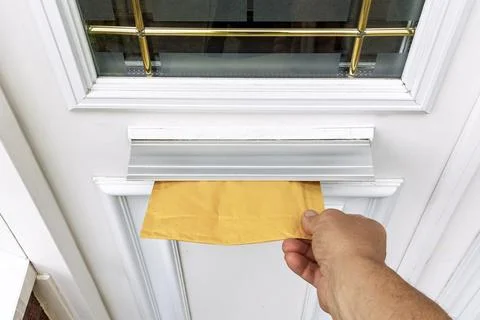 Point of View of Courier's Hand Pushing Padded Mailer Into Door Letterbox Stock Photos