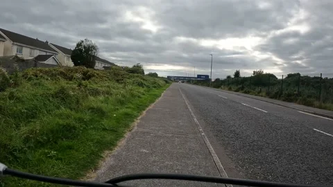 Point of view cycling on path towards large school Stock Footage 232960502