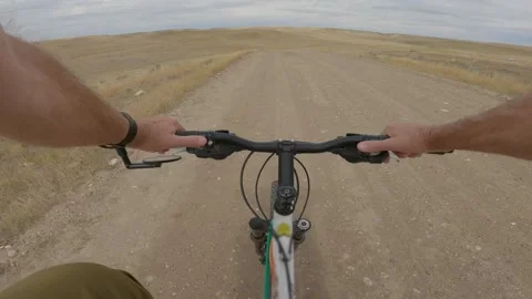 Point of view of a cyclist riding a bicycle along a gravel road  Stock Footage 275533718