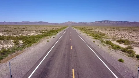 Point of view down ceter of longs straight road in desert Stock Footage 92829949