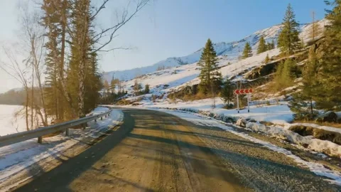 Point of view driving along a snowy mountain road at sunset Stock Footage 346636359