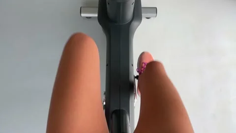 Point of view Female legs while cycling on a stationary bike Video stock 154560303