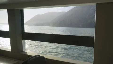 Point of view from ferry or boat window indoors as it sails in sea by cliffs Stock Footage 289417084