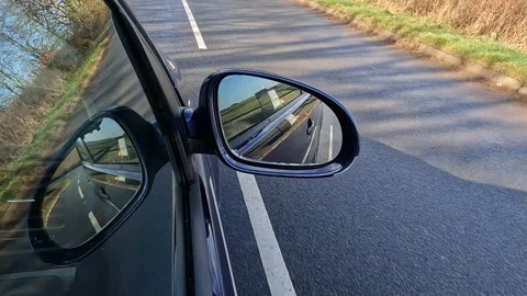 'Point of view' footage of VW golf car mirror on rural winter road Stock Footage 232763548